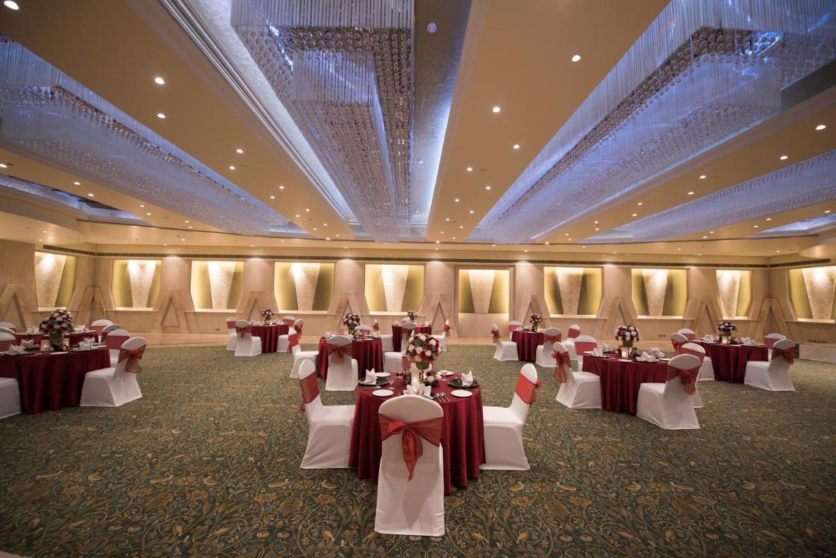 a banquet hall with tables and chairs in it at The Suryaa New Delhi in New Delhi a banquet hall with tables and chairs in it at The Suryaa New Delhi in New Delhi