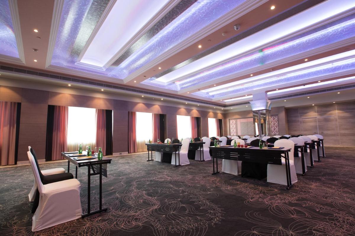 a banquet hall with tables and chairs in a room at The Suryaa New Delhi in New Delhi a banquet hall with tables and chairs in a room at The Suryaa New Delhi in New Delhi