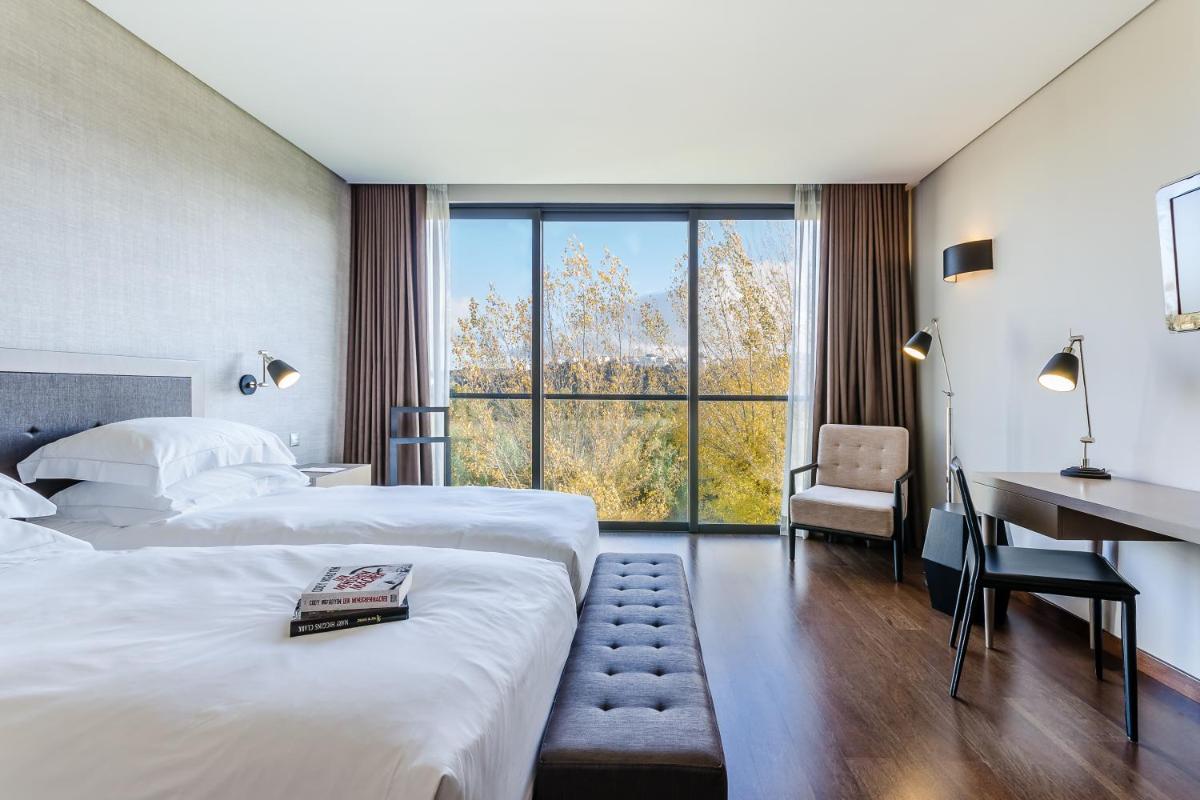 um quarto de hotel com duas camas e uma escrivaninha em Hotel Villa Batalha na Batalha
