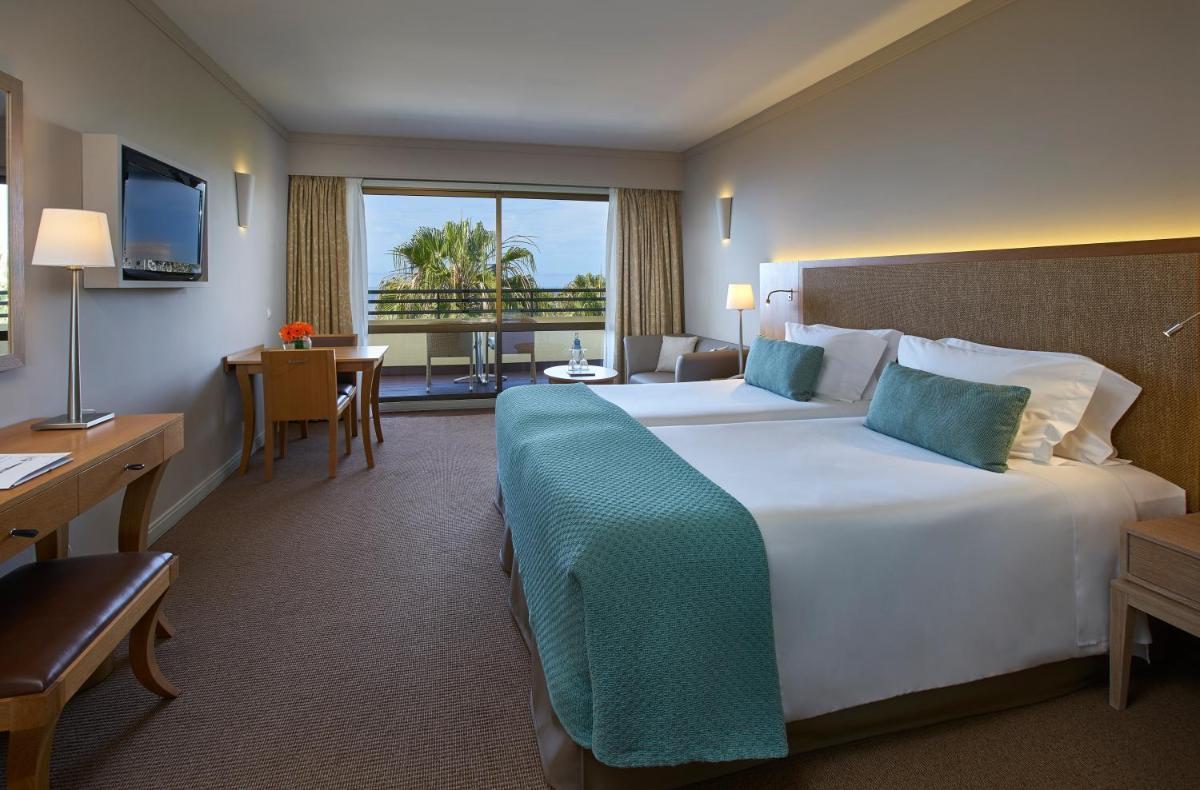 um quarto de hotel com uma cama grande e uma escrivaninha em Suite Hotel Eden Mar - PortoBay no Funchal mais 45 fotografias