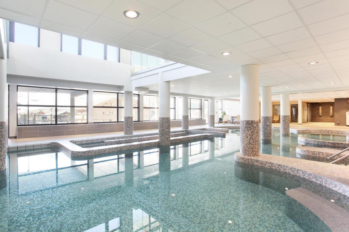 - une grande piscine d'eau dans un bâtiment dans l'établissement Hôtel Odalys Le Chamois, à La Clusaz