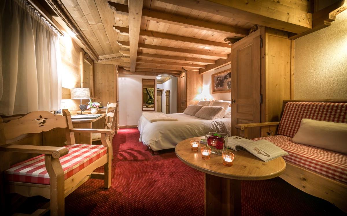 une chambre d'hôtel avec un lit, une table et des chaises dans l'établissement Hotel & Spa Le Dahu, à Morzine