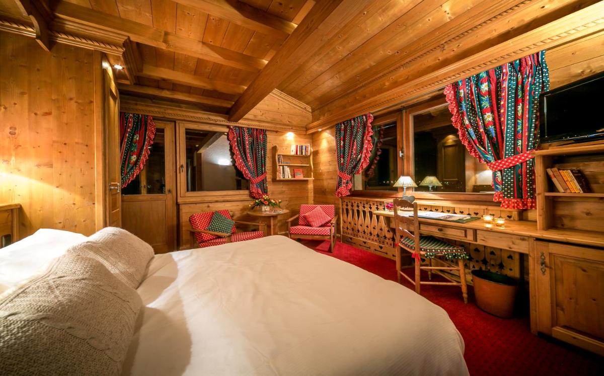 une chambre avec un lit et un bureau dans une pièce dans l'établissement Hotel & Spa Le Dahu, à Morzine 34 autres photos