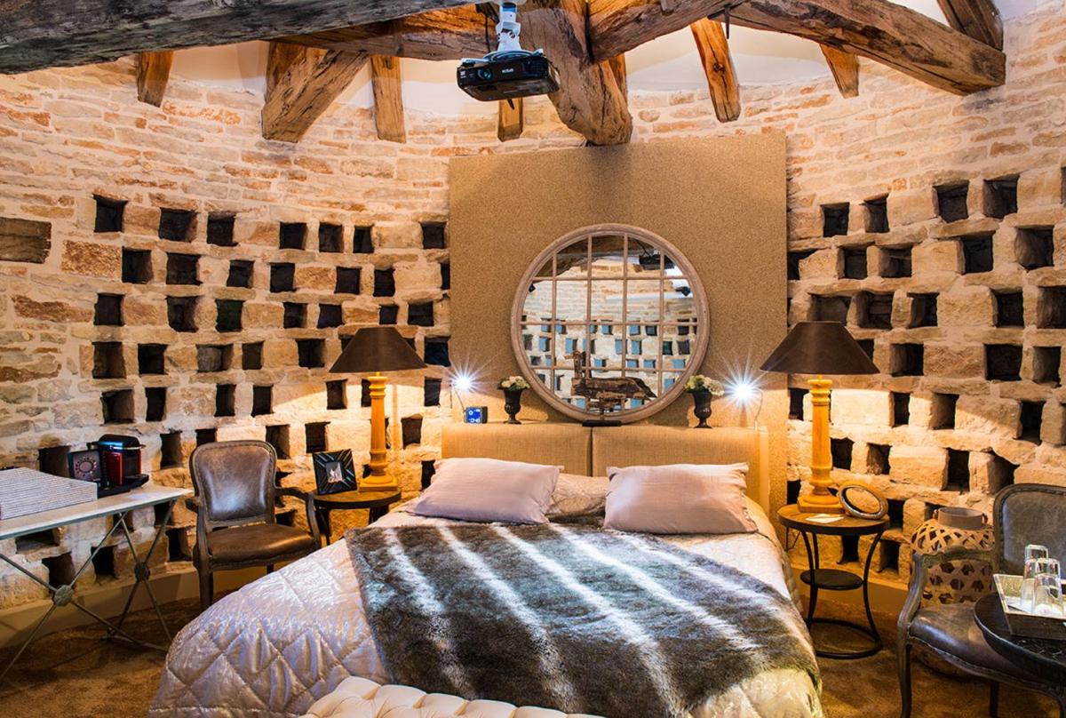 une chambre avec un lit et un miroir rond dans l'établissement Château de Courban and Spa Nuxe, à Courban 63 autres photos