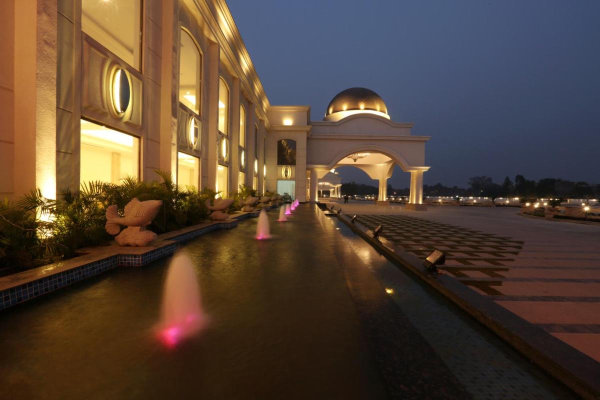 a building with a pool of water in front of a building at Ramada by Wyndham Lucknow Hotel and Convention Center in Lucknow