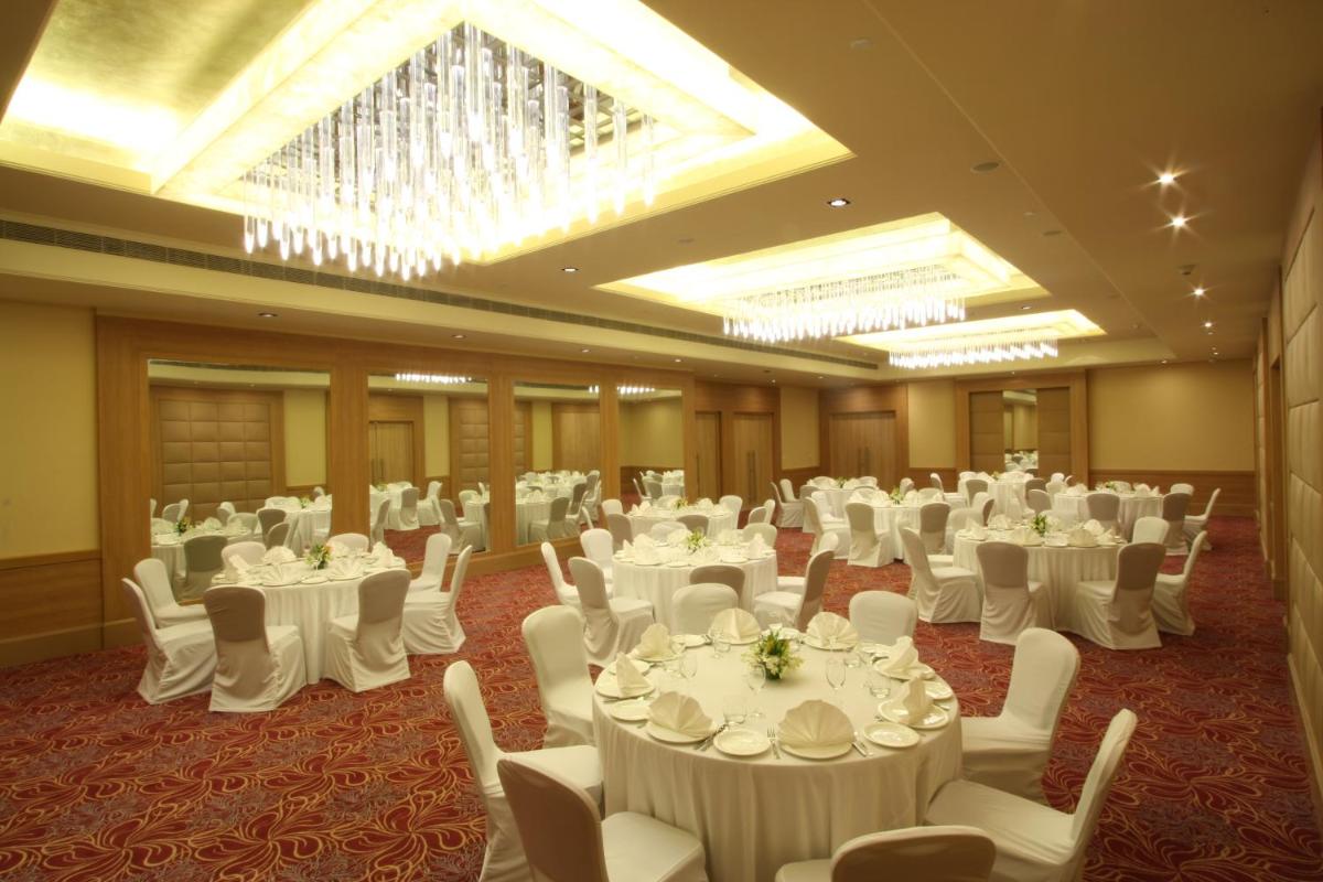 a banquet hall with white tables and white chairs at Radisson Hyderabad Hitec City in Hyderabad