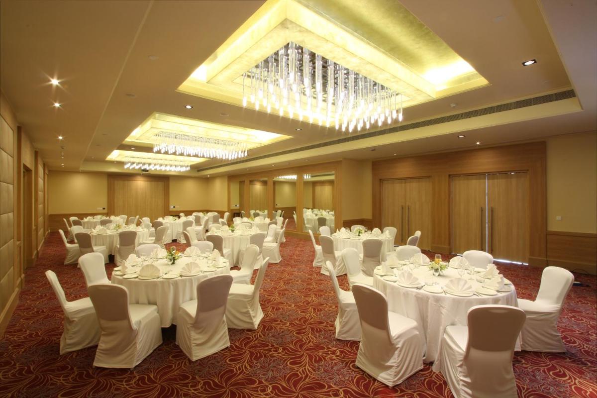 a banquet hall with white tables and white chairs at Radisson Hyderabad Hitec City in Hyderabad