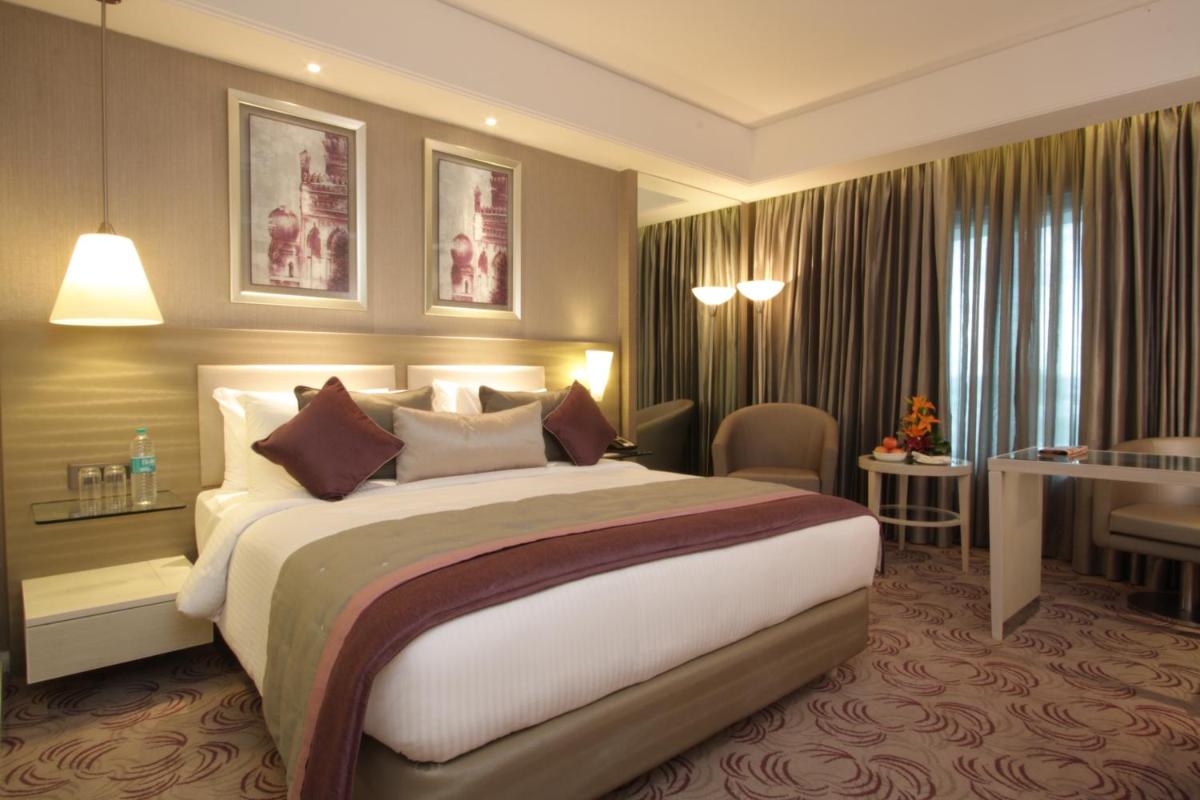 a hotel room with a large bed and a table at Radisson Hyderabad Hitec City in Hyderabad