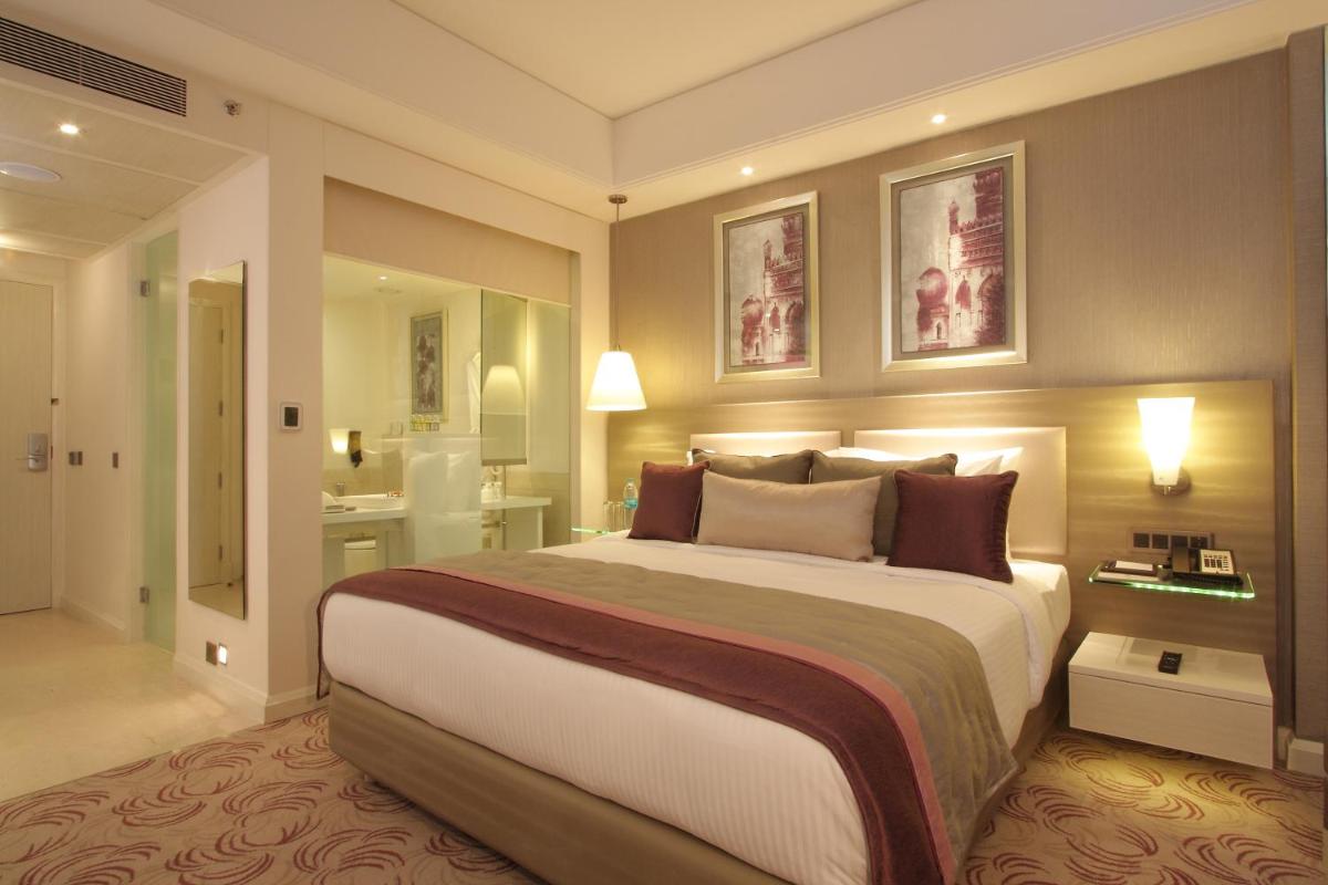 a bedroom with a large bed and a bathroom at Radisson Hyderabad Hitec City in Hyderabad