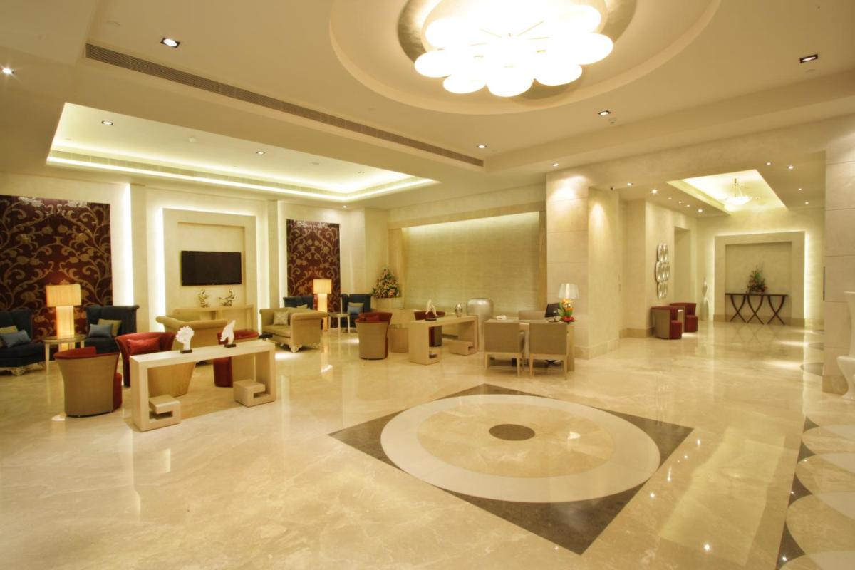 a lobby of a hotel with a large room with tables and chairs at Radisson Hyderabad Hitec City in Hyderabad