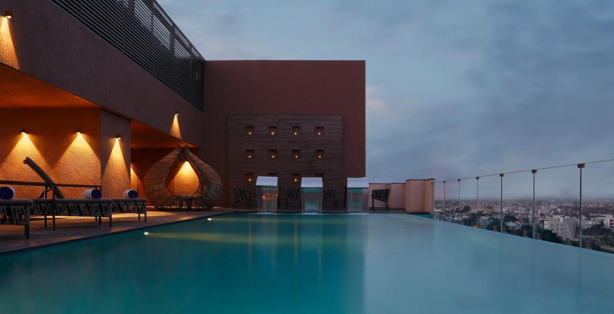 a large swimming pool on the roof of a building at Novotel Lucknow Gomti Nagar in Lucknow