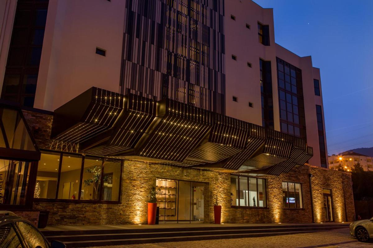 um prédio com a fachada iluminada à noite em Puralã - Wool Valley Hotel & SPA na Covilhã
