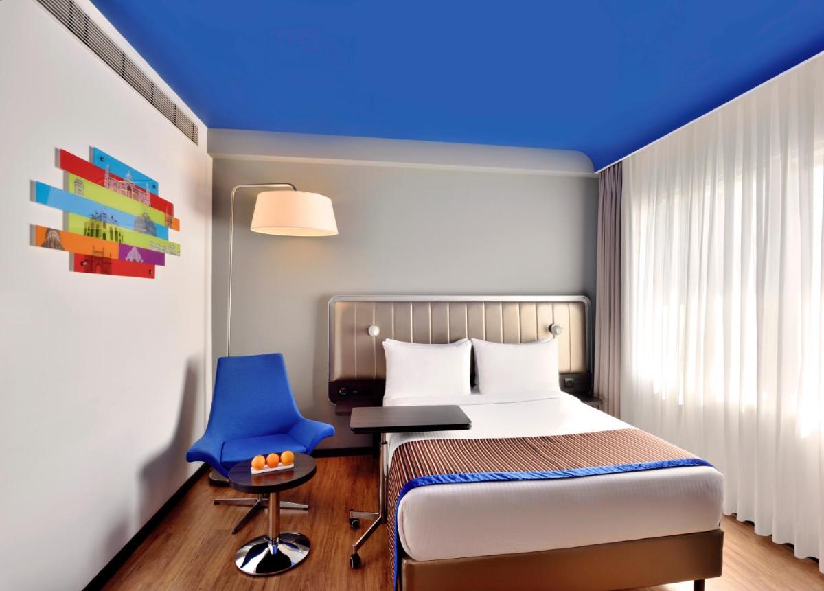 a bedroom with a bed and a blue ceiling at Park Inn by Radisson,South Delhi in New Delhi a bedroom with a bed and a blue ceiling at Park Inn by Radisson,South Delhi in New Delhi