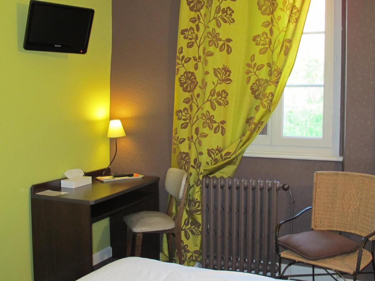 une chambre avec un lit, un bureau et une fenêtre dans l'établissement Logis Deshors-Foujanet, à Chamboulive
