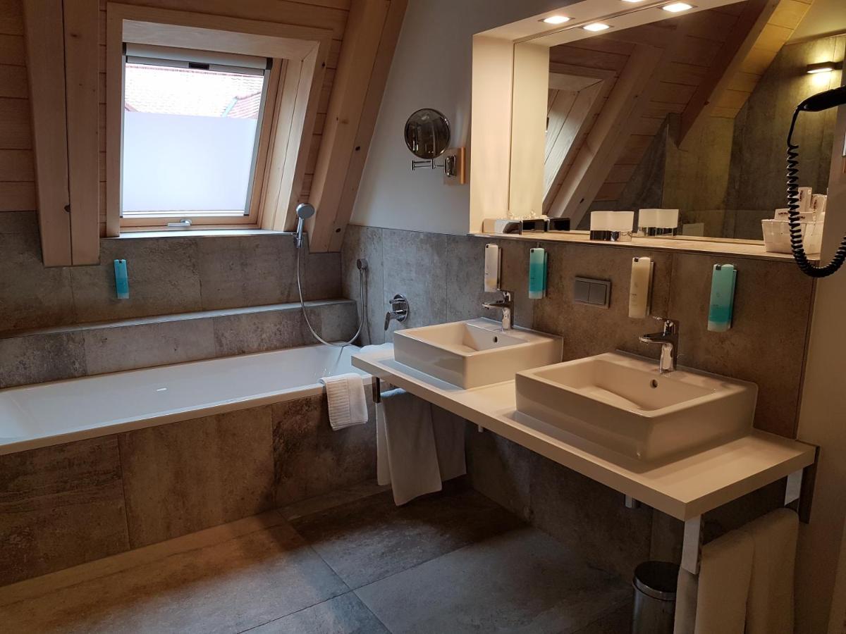 ein Badezimmer mit zwei Waschbecken und einer Badewanne und einem Spiegel in der Unterkunft Gästehaus der Geroldsauer Mühle in Baden-Baden
