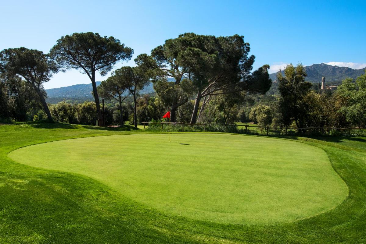 un campo de golf con un campo verde y árboles en Mas Tapiolas, en Santa Cristina d'Aro