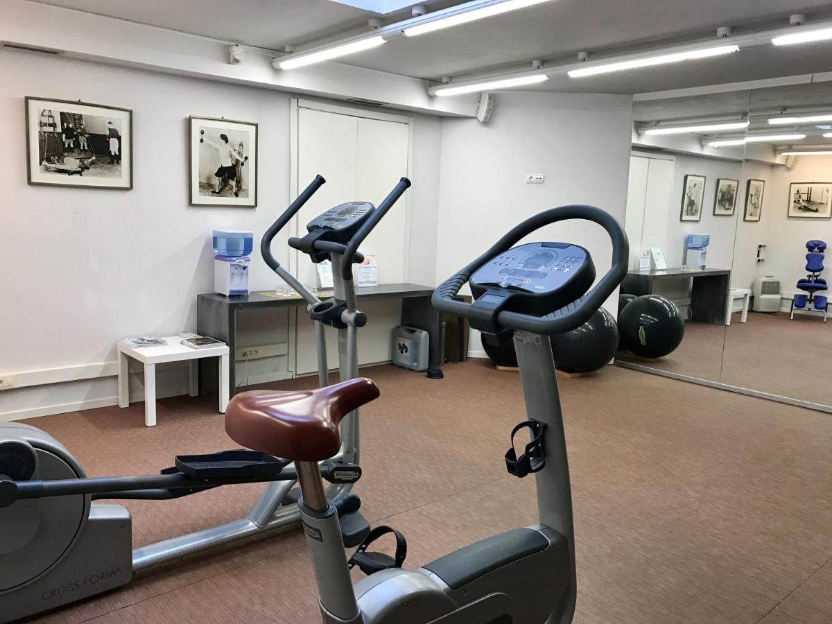 Un gimnasio con dos bicicletas estáticas en una habitación. en Hotel Villa Paulita, en Puigcerdà