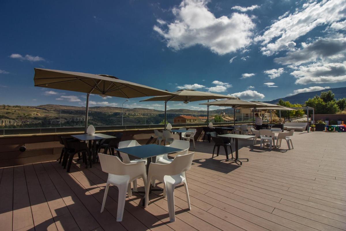 Un patio con mesas, sillas y sombrillas. en Hotel Spa Balfagon, en Cantavieja 49 fotos más
