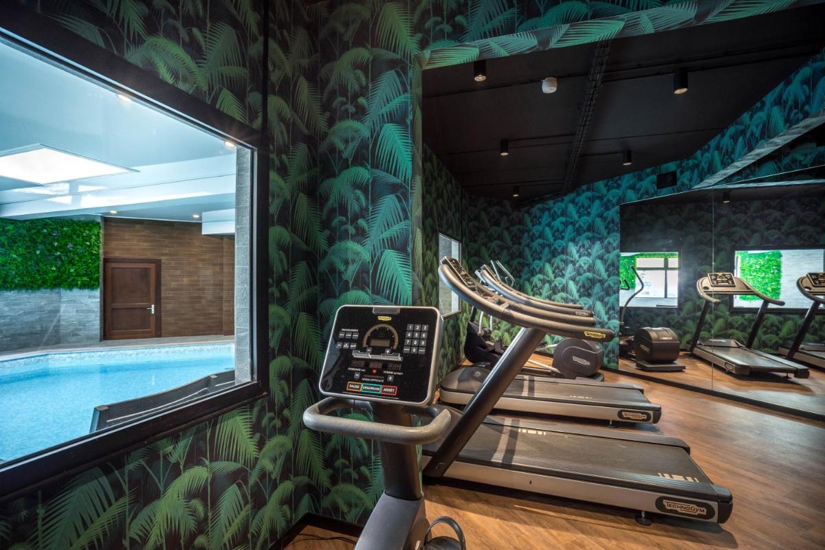 une salle de sport avec une piscine et un tapis roulant dans l'établissement Best Western Plus Hostellerie Du Vallon, à Trouville-sur-Mer