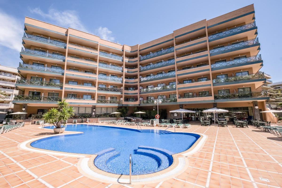 Un gran edificio de apartamentos con una gran piscina. en Hotel California Palace, en Salou