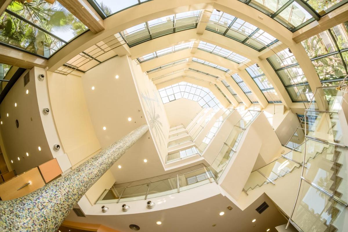 una escalera interior en un edificio con techo de cristal en Hotel California Palace, en Salou 40 fotos más