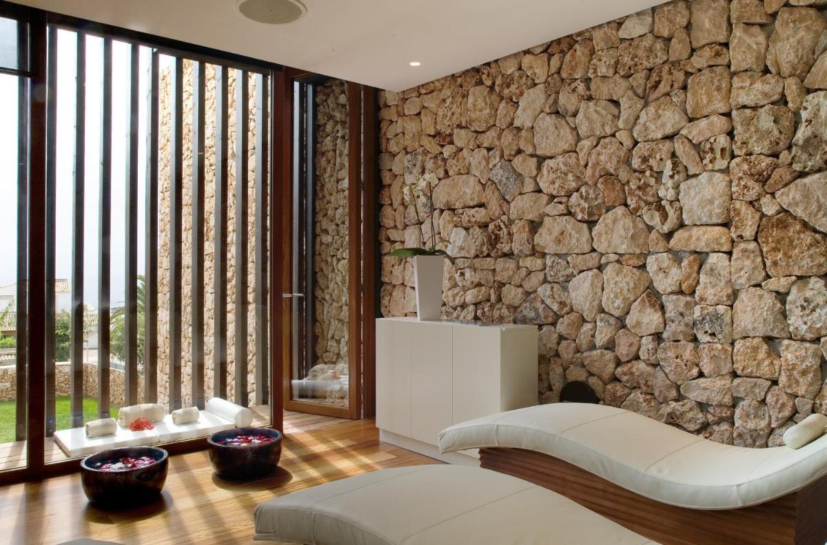una sala de estar con una pared de piedra en Hospes Maricel y Spa, Palma de Mallorca, a Member of Design Hotels, en Cas Català
