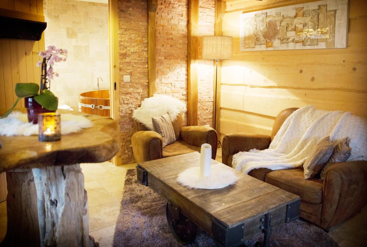 Coin salon dans l'établissement Domaine du Haut Jardin Hôtel & Chalets Spa Privé