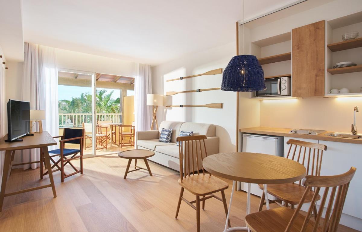 Una sala de estar y una cocina con mesa y sillas. en Club del Sol Aparthotel, en Puerto Pollensa
