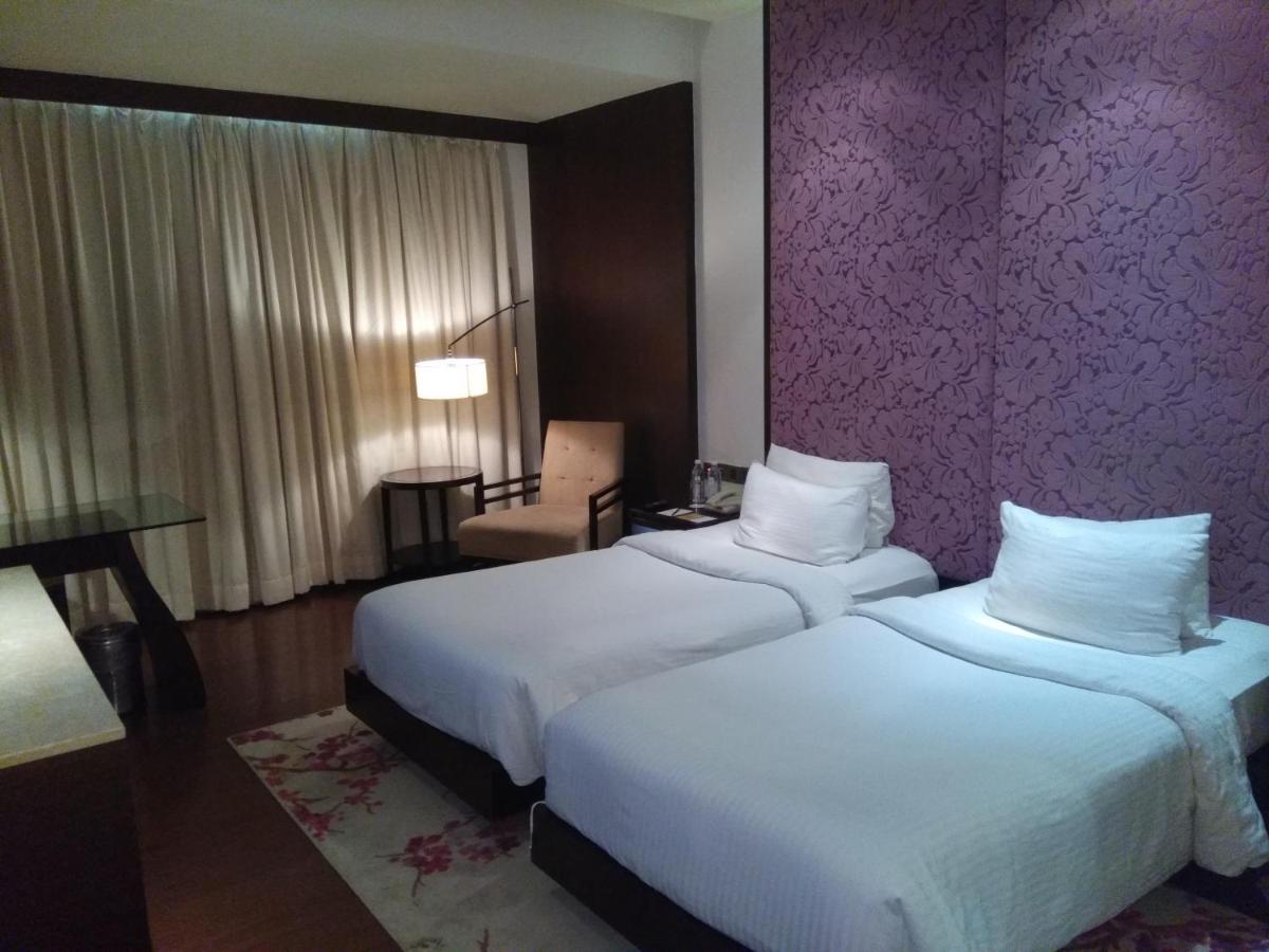 a hotel room with two beds and a purple wall at Hotel Royal Orchid Jaipur, Tonk Road in Jaipur