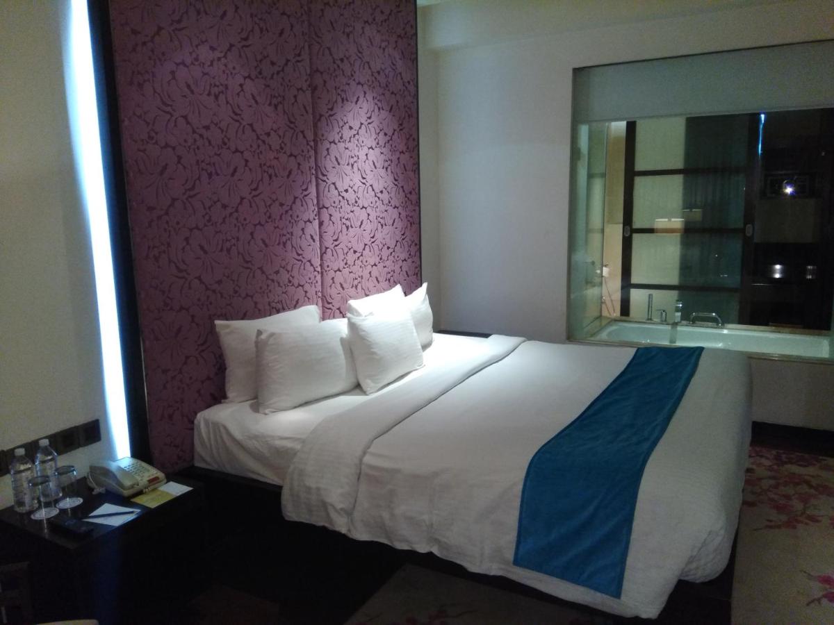 a hotel room with a large bed and a bathroom at Hotel Royal Orchid Jaipur, Tonk Road in Jaipur