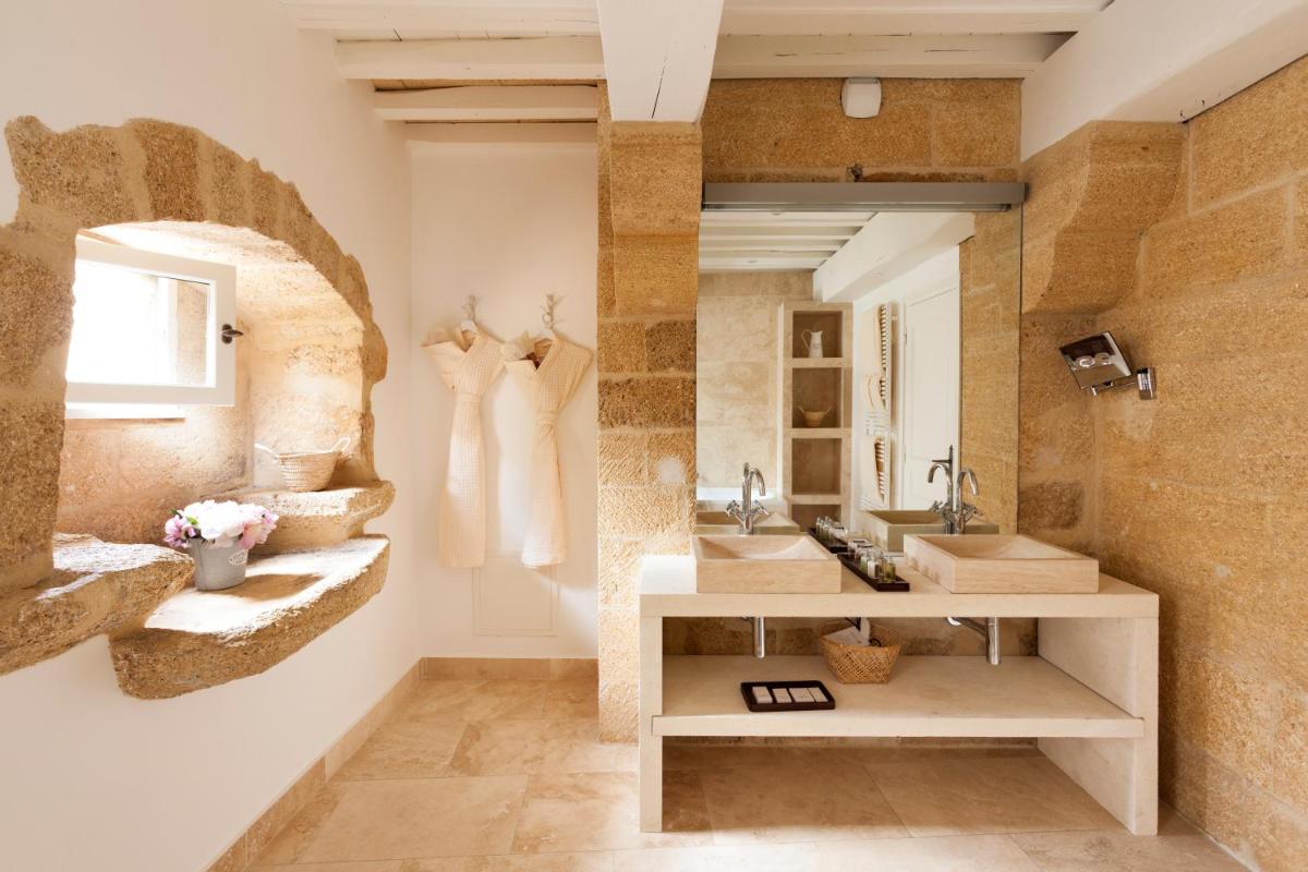 une salle de bain avec deux lavabos et un miroir dans l'établissement Le Vieux Castillon, à Castillon-du-Gard