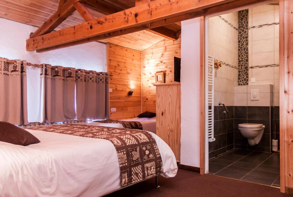 Cet appartement comprend une chambre avec deux lits et une salle de bains pourvue d'une douche. dans l'établissement Hotel Spa L'Equipe, à Molines-en-Queyras