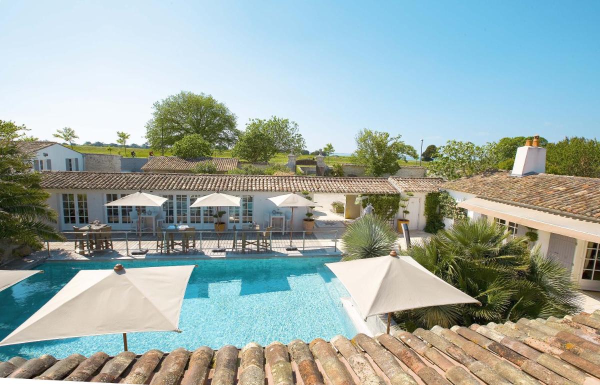 une image d'une piscine avec parasols dans l'établissement Le Clos Saint-Martin Hôtel & Spa, à Saint-Martin-de-Ré