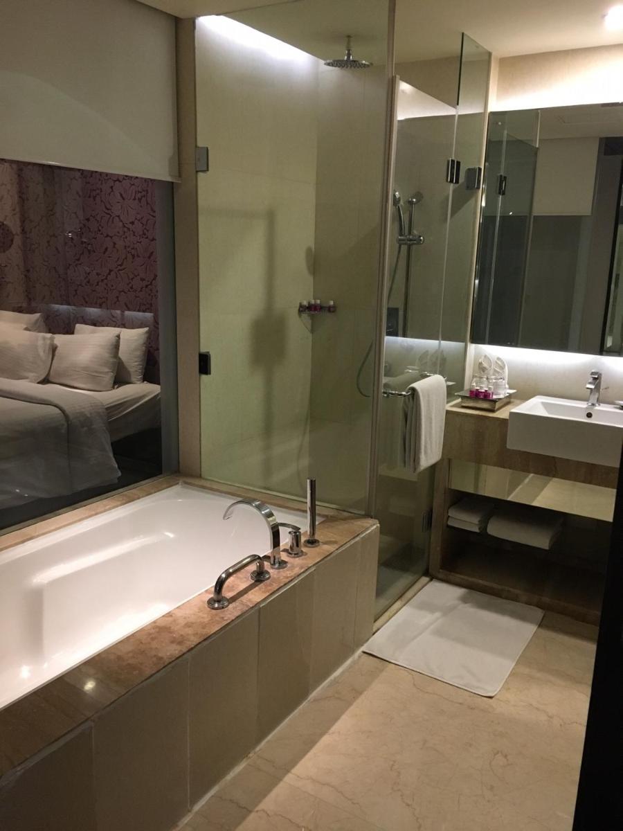 a bathroom with a tub and a sink and a bed at Hotel Royal Orchid Jaipur, Tonk Road in Jaipur