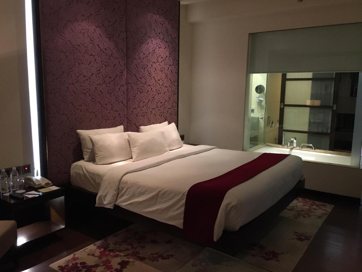 a bedroom with a large bed and a window at Hotel Royal Orchid Jaipur, Tonk Road in Jaipur