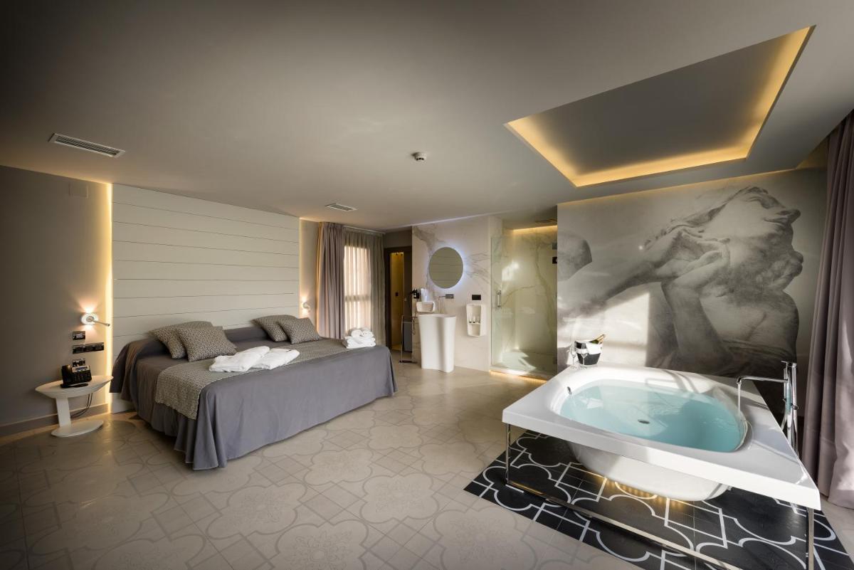 un dormitorio con una cama y una bañera en Hotel Spa Elia, en Alcalá del Júcar 49 fotos más