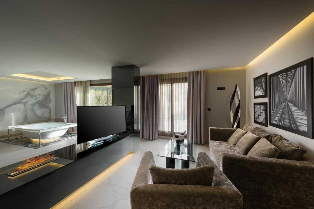Una sala de estar con dos sofás y un televisor. en Hotel Spa Elia, en Alcalá del Júcar
