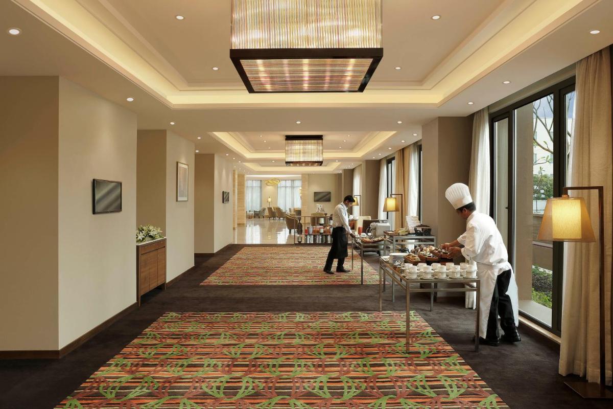 a lobby of a hotel with two chefs preparing food at Novotel Lucknow Gomti Nagar in Lucknow