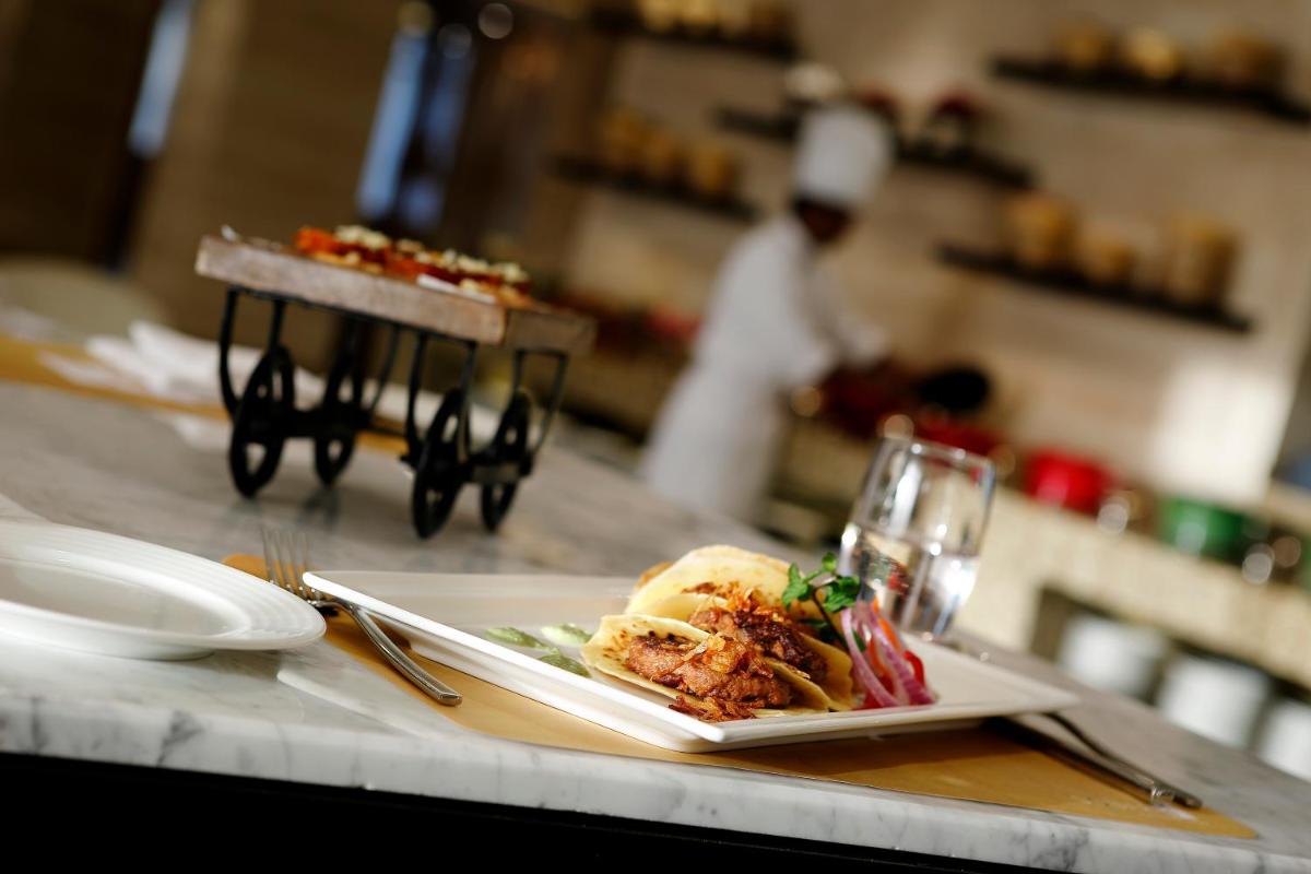 a plate of food on a counter in a restaurant at Novotel Lucknow Gomti Nagar in Lucknow