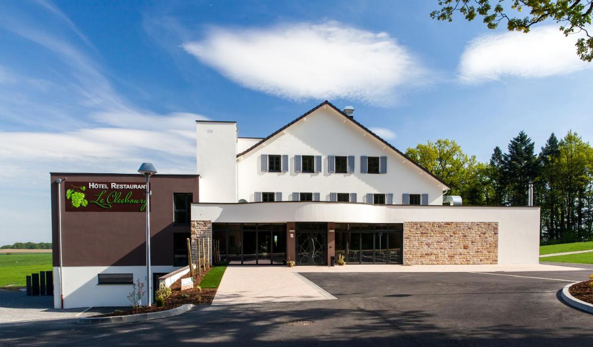 un bâtiment blanc avec un panneau devant dans l'établissement Hotel Restaurant Le Cleebourg, à Rott