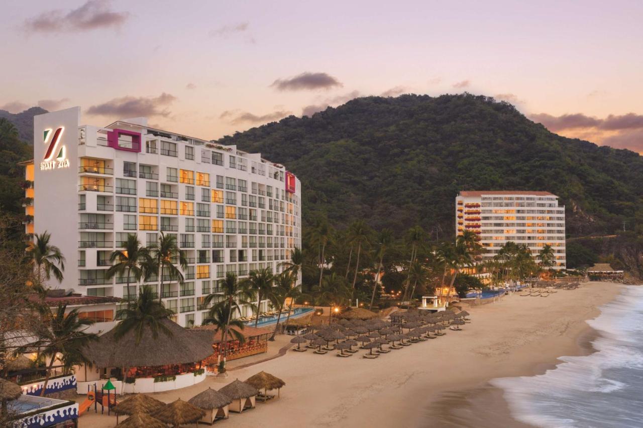 hotel with trees, hut, umbrella lounges, beach