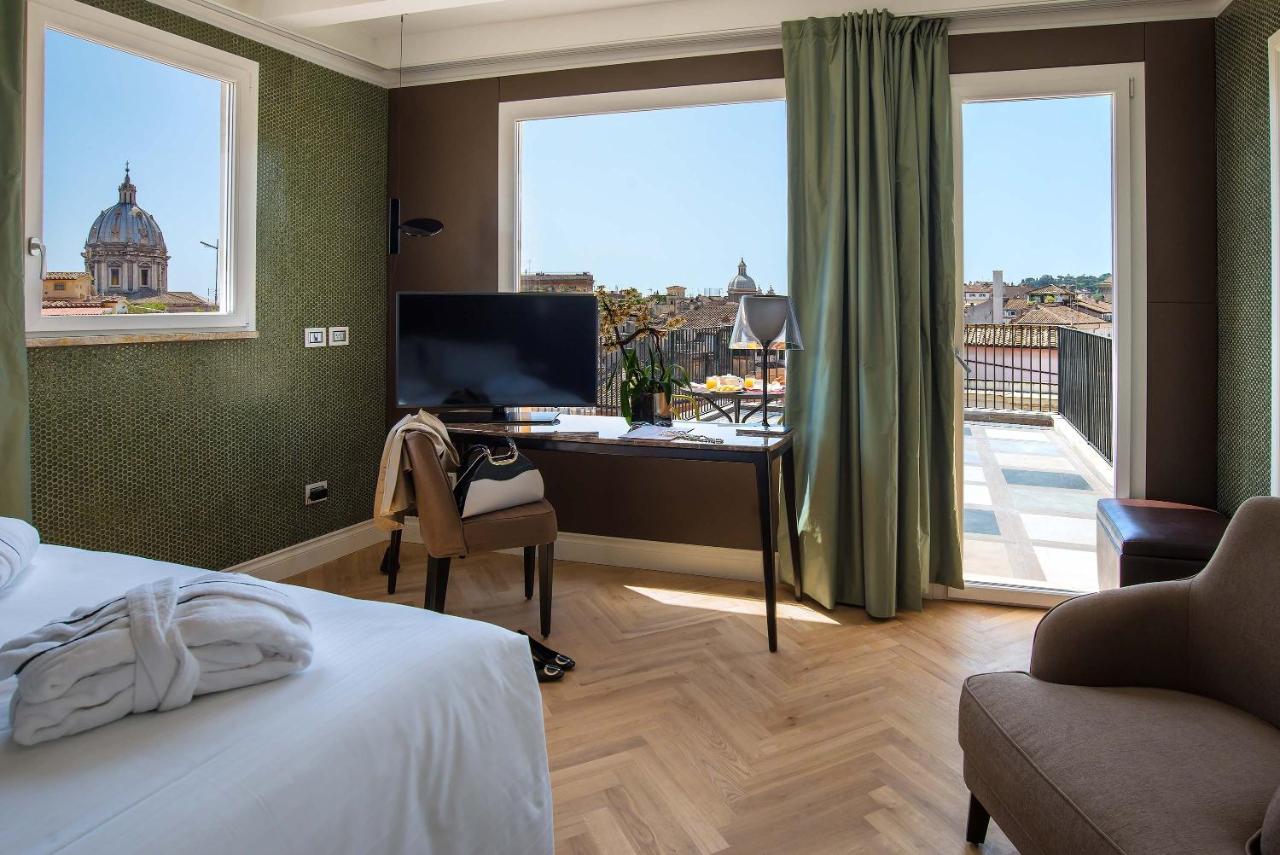 Quarto no Hotel Damaso com cama de casal, vista, televisão, aparador e boa iluminação.