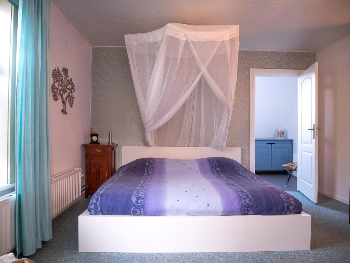 a bedroom with a bed with a canopy at De Drie Linden in Leerdam
