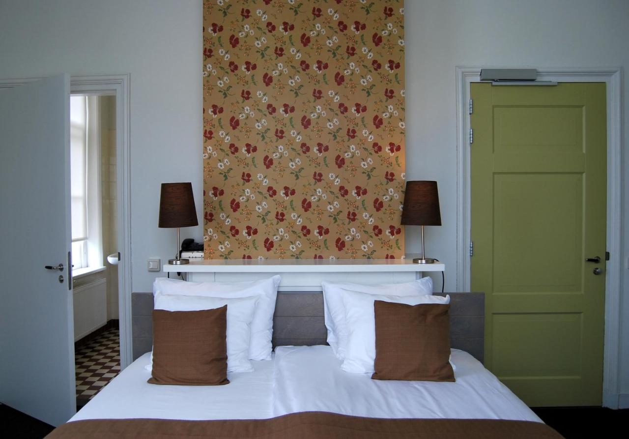 a bedroom with a bed with a green door at Bitter en Zoet in Veenhuizen