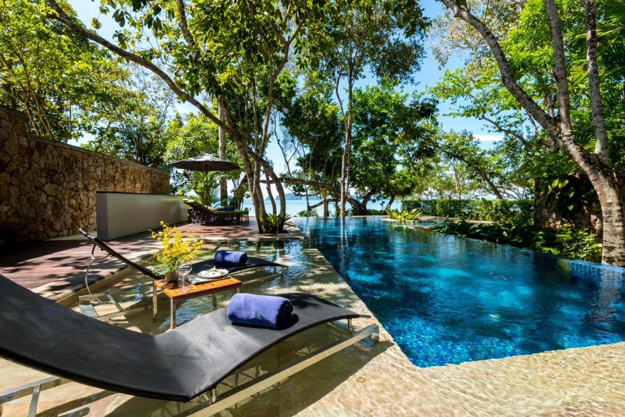 pool with trees and lounge chair with towels