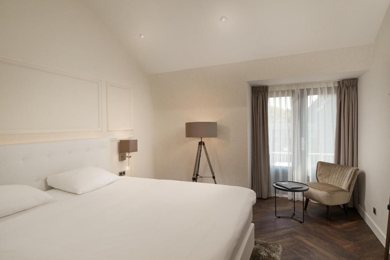 Een bed of bedden in een kamer bij Hotel De Lindeboom