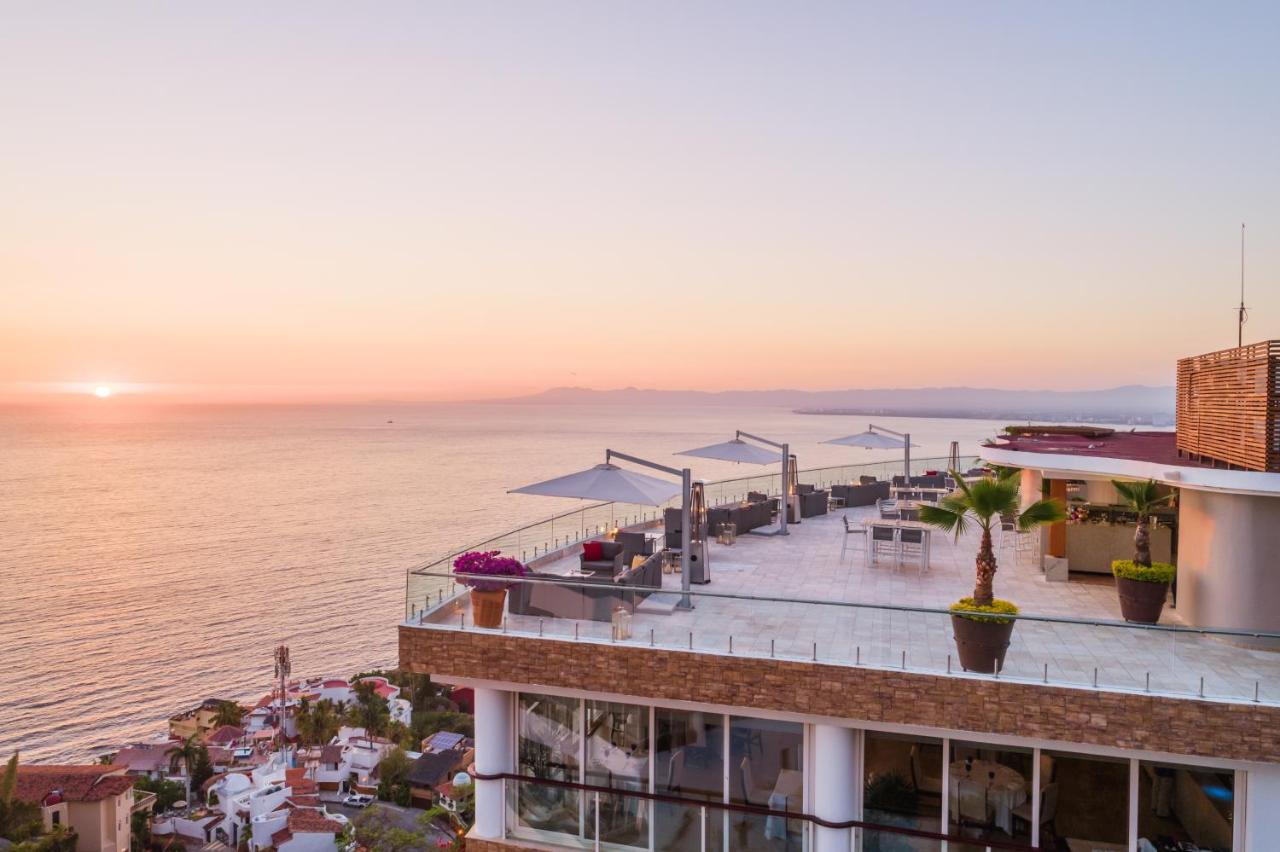 hotel with sunset view overlooking ocean with umbrella cabanas