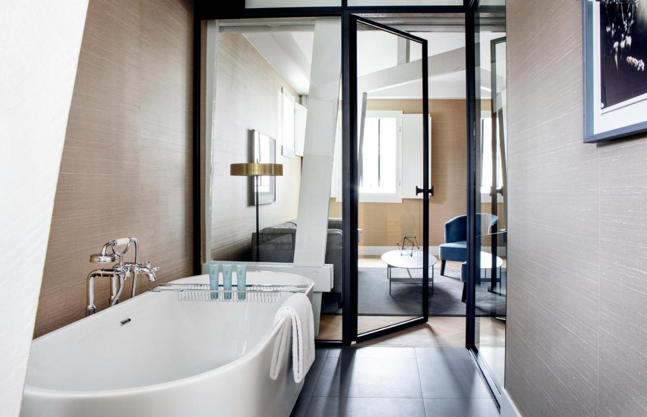 a bathroom with a bath tub and a large mirror at Pillows Grand Boutique Hotel Reylof Ghent in Ghent