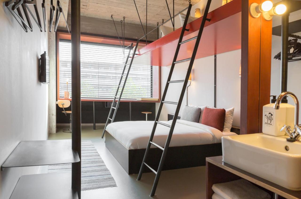 a bedroom with a bunk bed and a bathroom at Volkshotel in Amsterdam