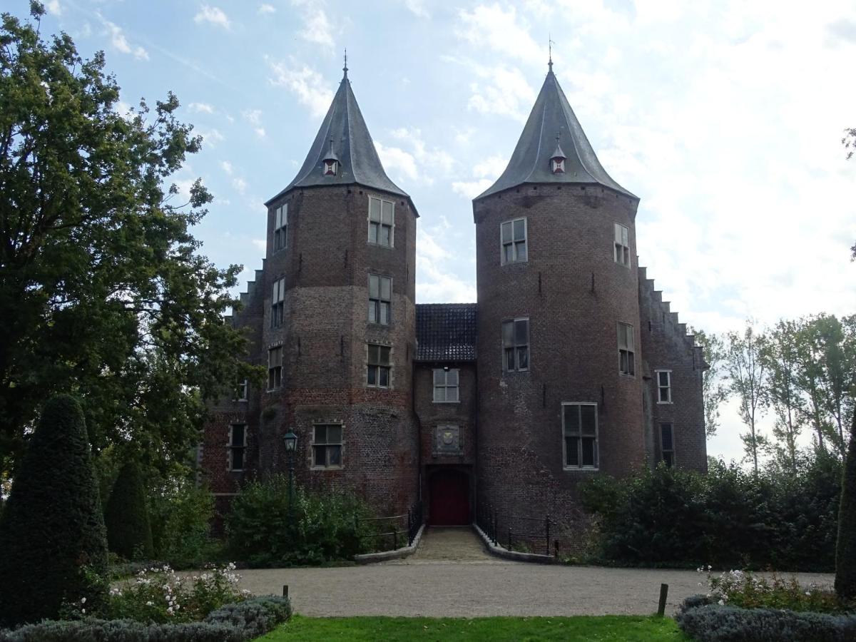 an old brick building with two towers on top at De Oude Stoffeerderij in Dussen